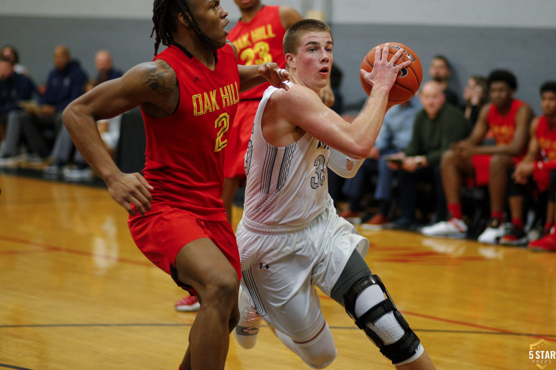 Grant Ledford of Grace Christian (white jersey) drives into the lane with Oak Hill Academy's Christian Brown defending. (Photo: Danny Parker).